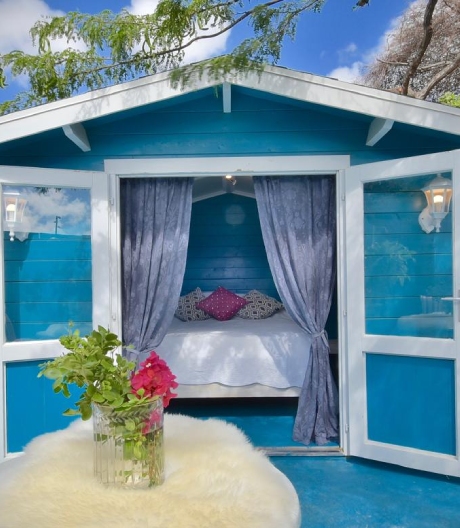 Bohemian Outdoor Casita at Mammaloe’s Aruba with blue exterior, open patio and pink door