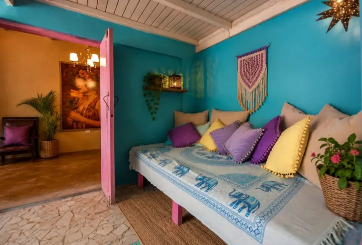 Boho Luxe Room with turquoise walls, daybed and colorful cushions