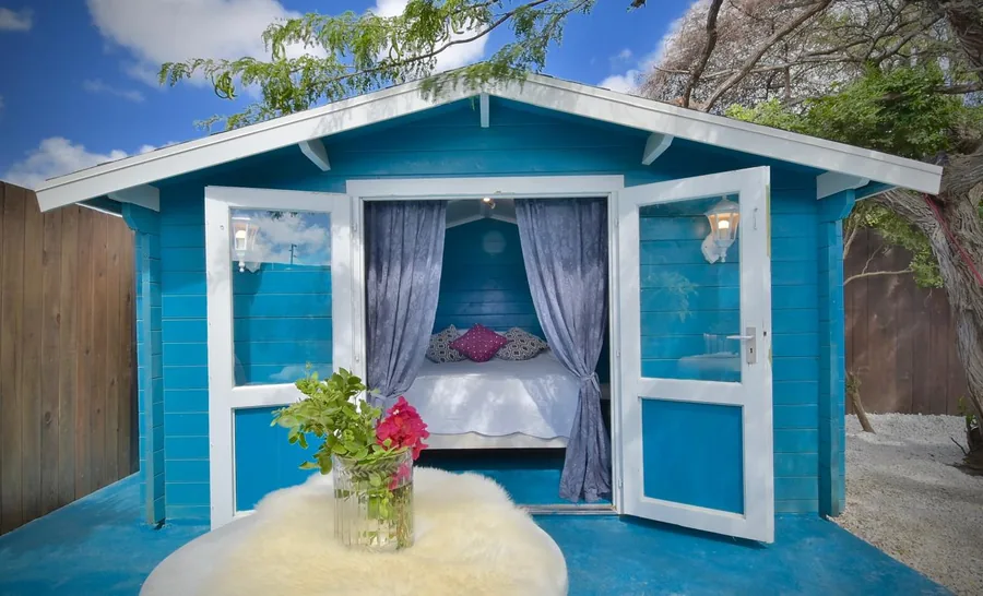 Lavendel, a blue Outdoor Casita with lavender curtains and open French doors